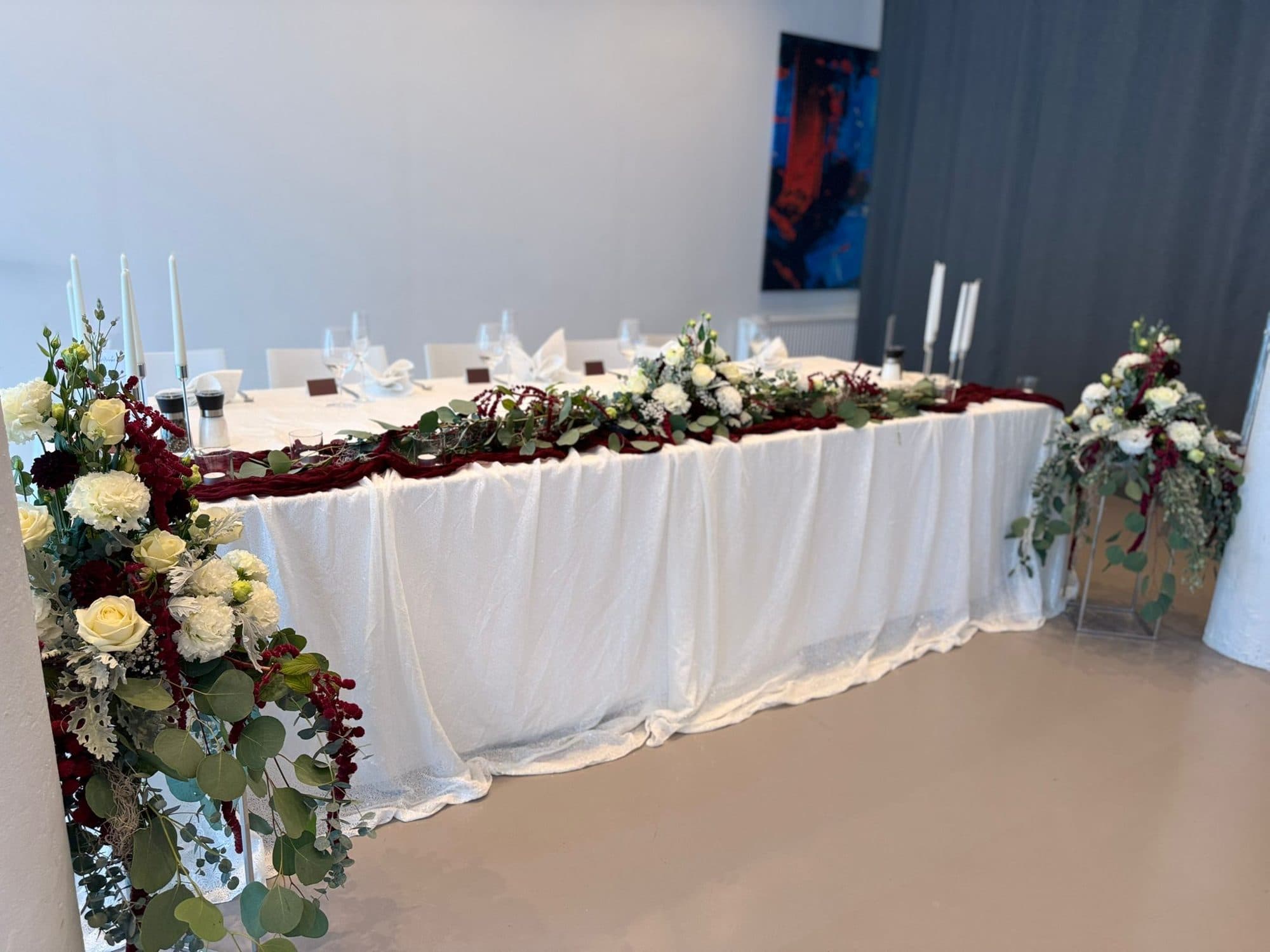 Festlich gedeckte Brauttafel mit Blumengirlande in Bordeaux und Weiß in der Eventlocation REST2RENT Hamburg
