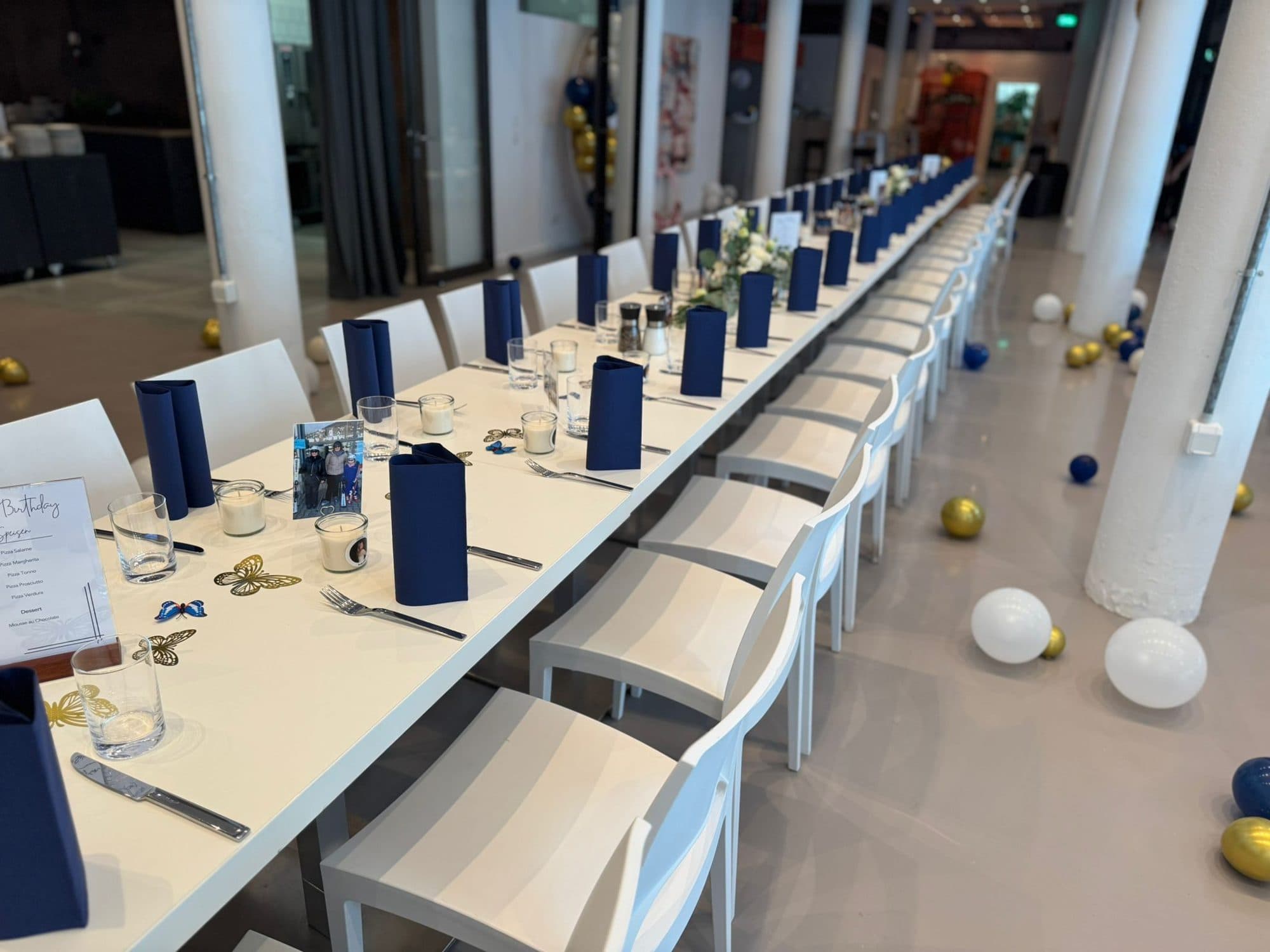 Lange Geburtstagstafel mit dunkelblauen Servietten in der Eventlocation REST2RENT Hamburg