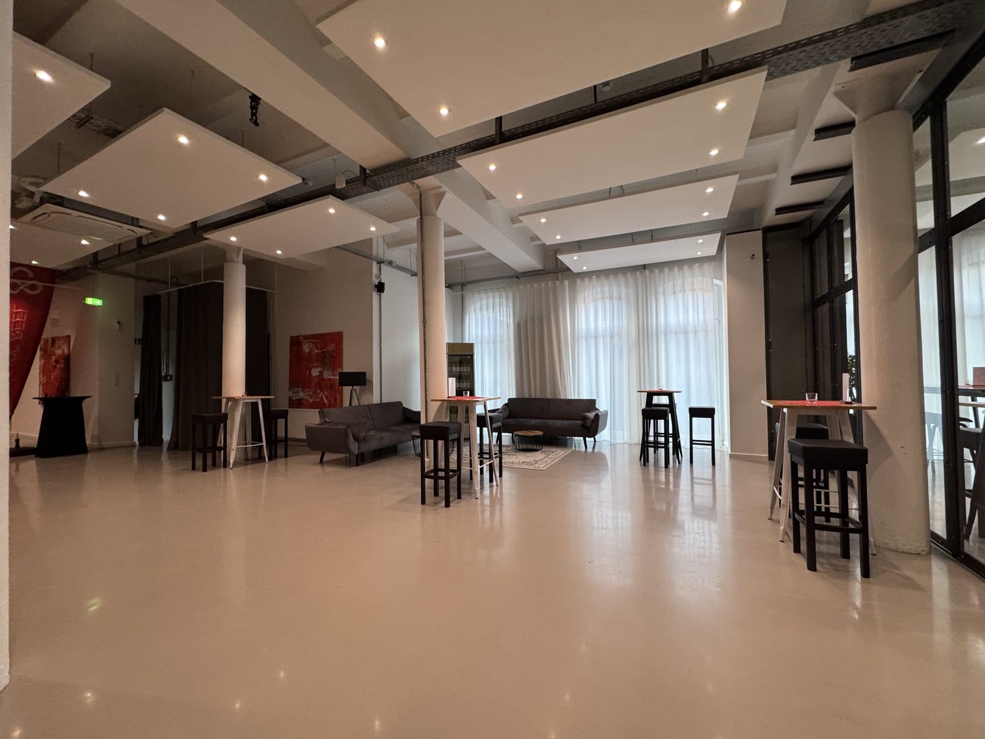 Wide event space with columns and lounge at the REST2RENT event venue in Hamburg