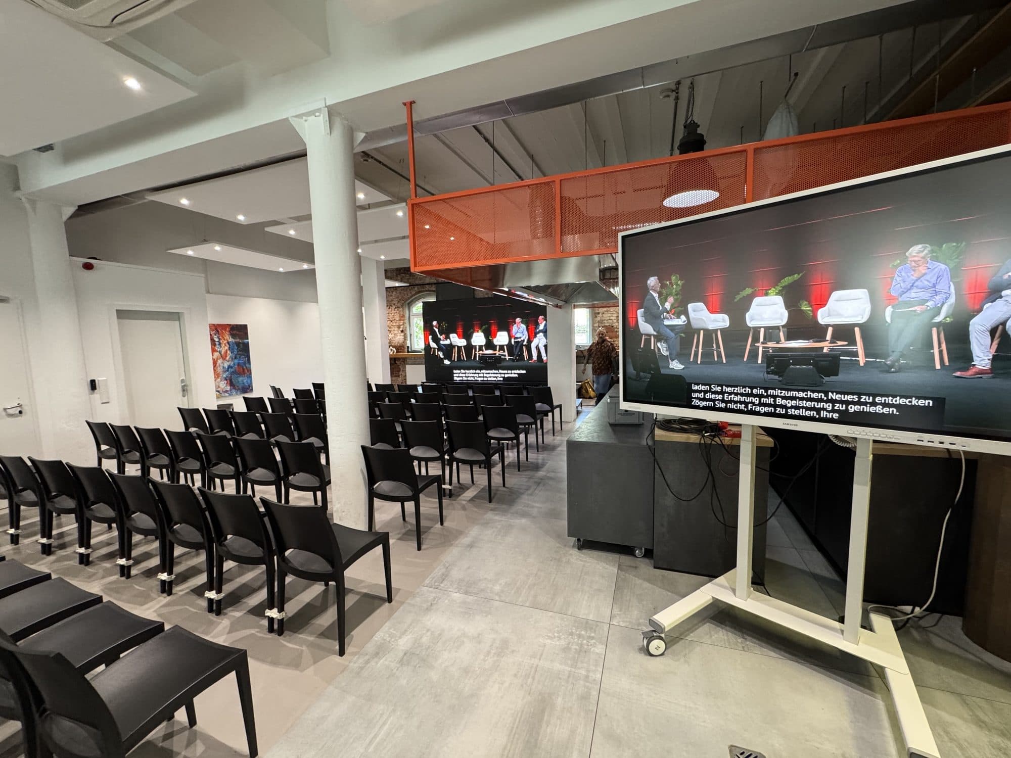 Reihenbestuhlung mit 85-Zoll-Screen im Loft in der Eventlocation REST2RENT Hamburg