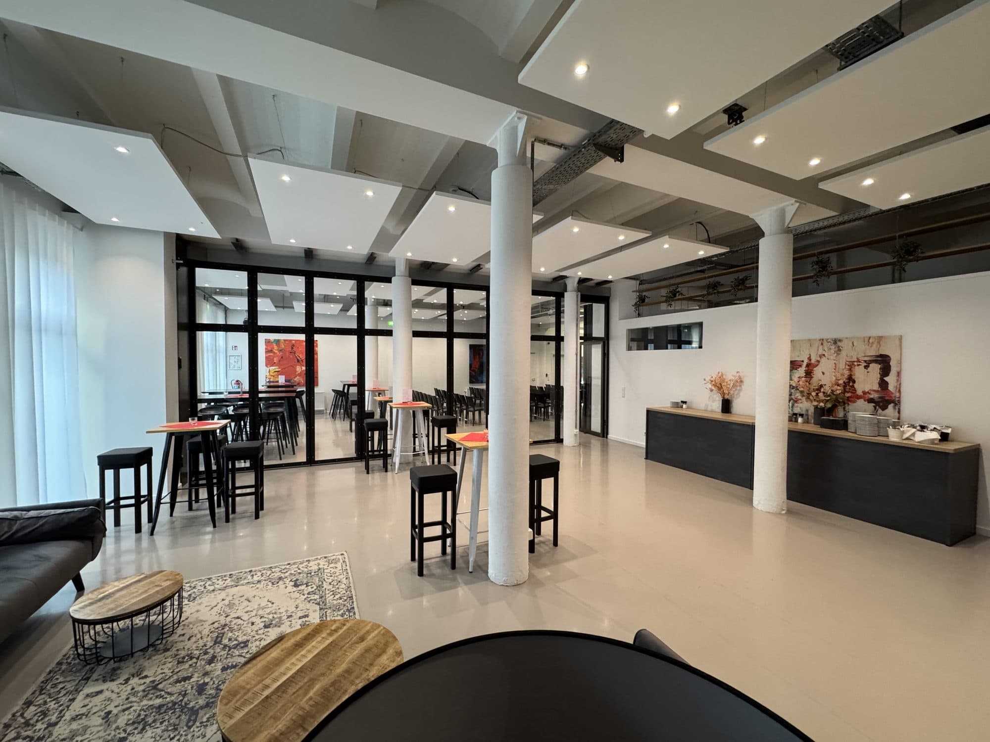 Loft with lounge, glass partition and standing tables at the REST2RENT event venue in Hamburg
