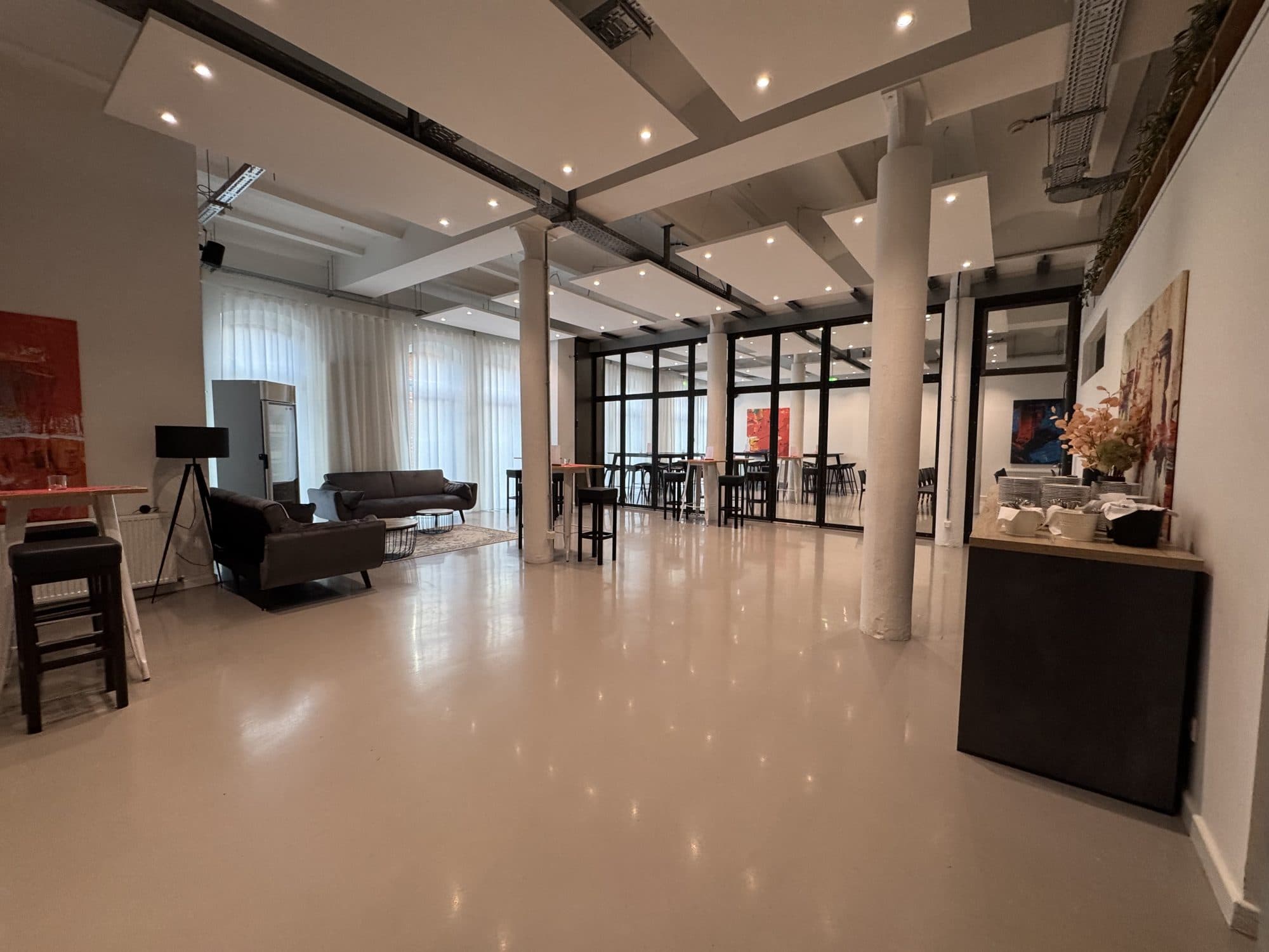 Bright event space with sofas and columns at the REST2RENT event venue in Hamburg