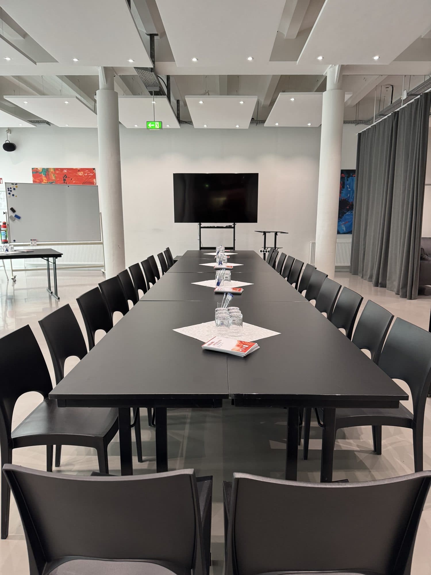 Lange Konferenztafel mit Bildschirm in der Eventlocation REST2RENT Hamburg