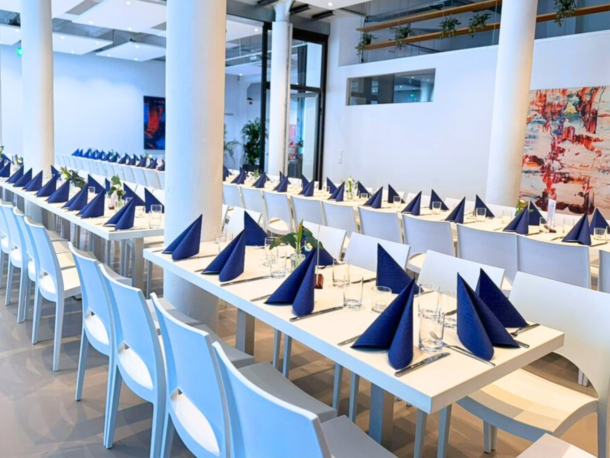 Bankett an langen Tafeln bei Tageslicht zwischen den Säulen in der Eventlocation REST2RENT Hamburg