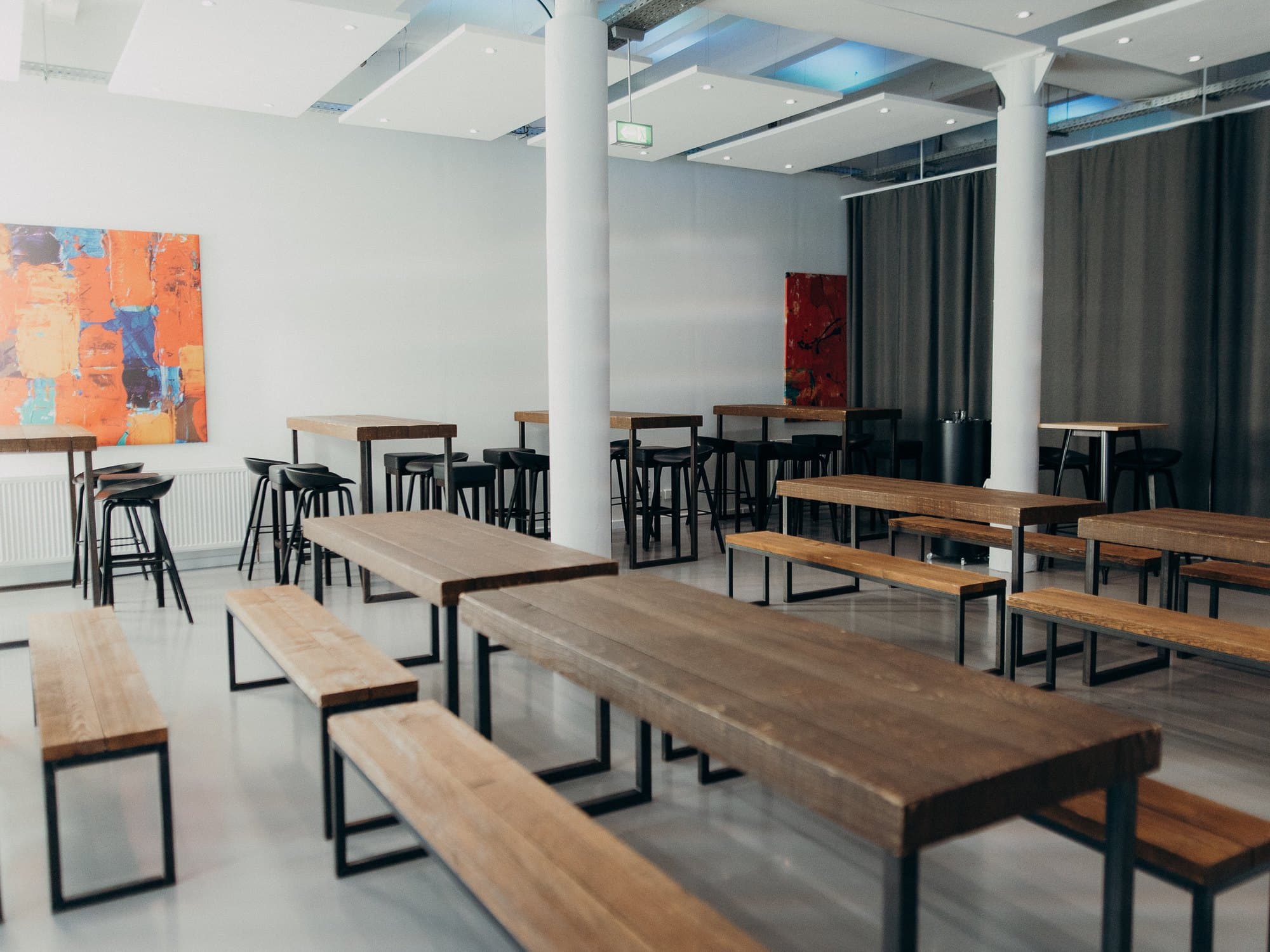 Long banquet tables set for a festive dinner in the bright event space at REST2RENT Hamburg