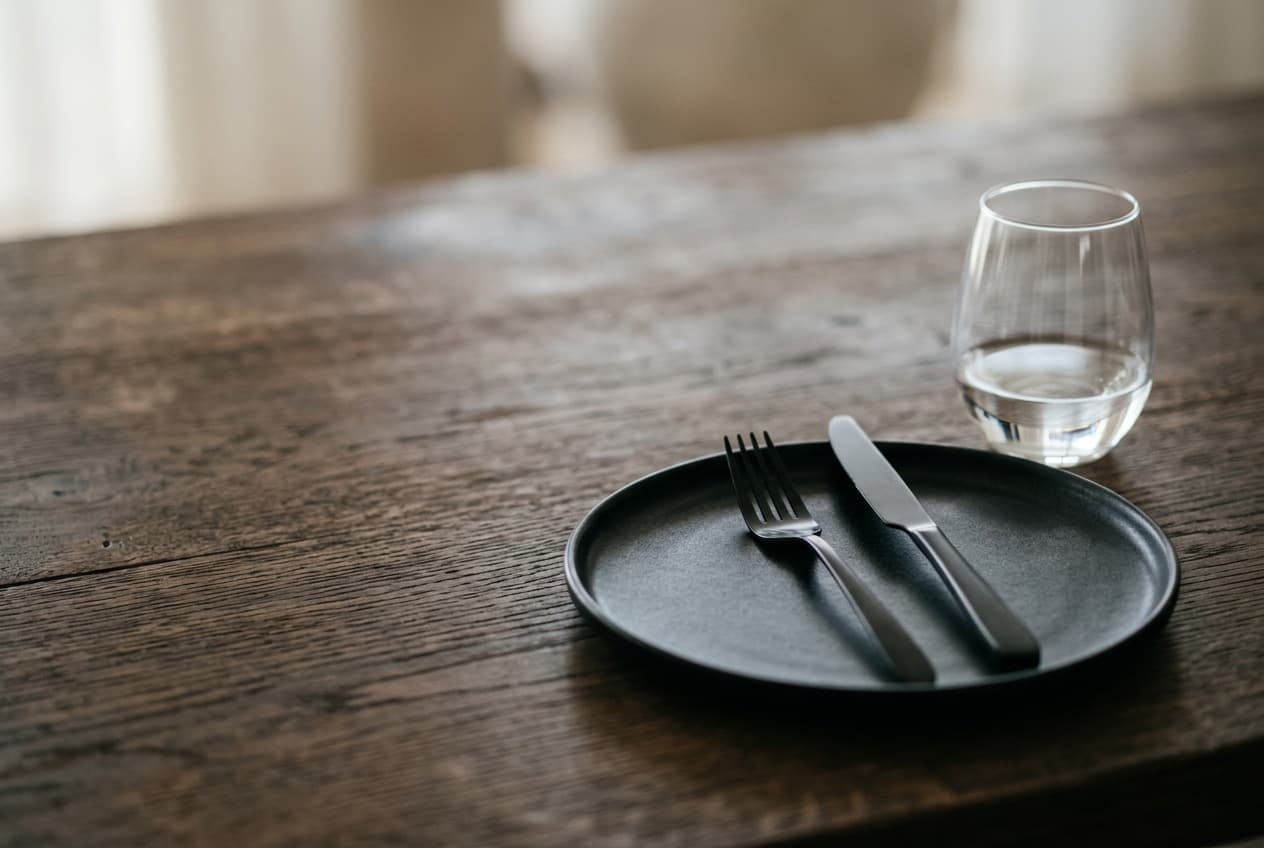 Modern eingedecktes Gedeck mit mattem Geschirr und Glas auf Eichentisch — REST2RENT Eventlocation Hamburg