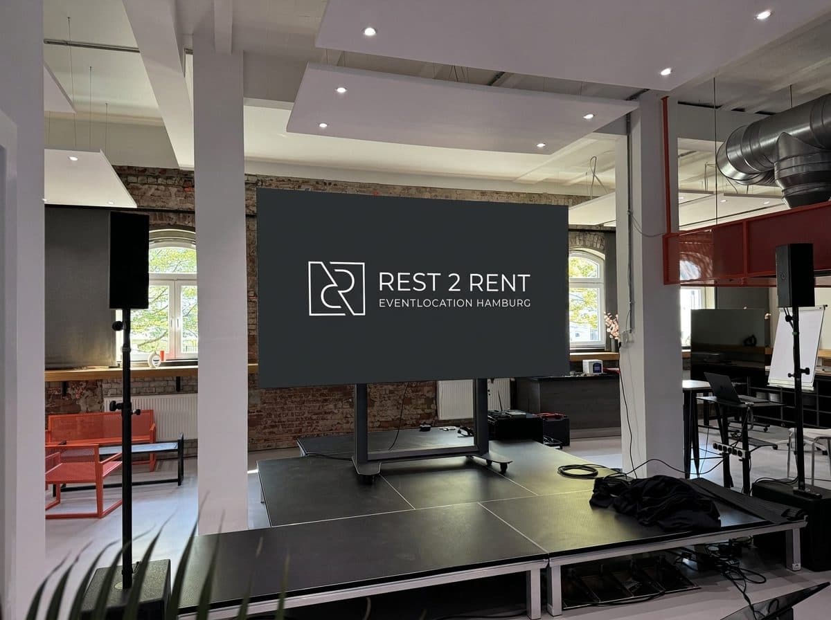 Bühne mit großem Screen und REST2RENT-Logo in der Eventlocation Hamburg